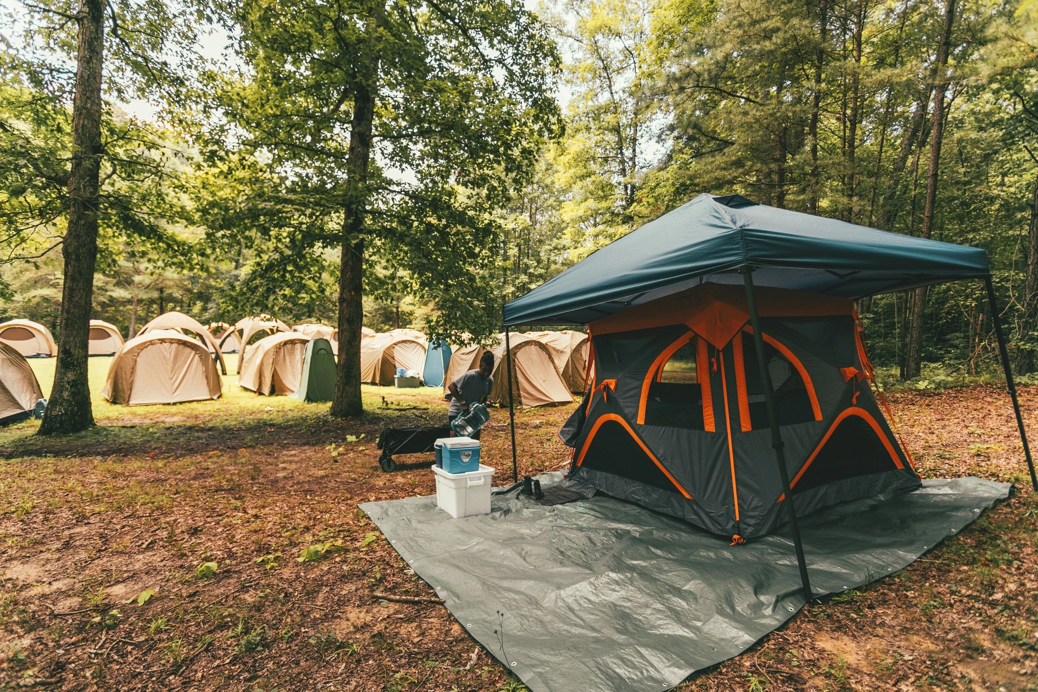 Person setting up a campsite tent